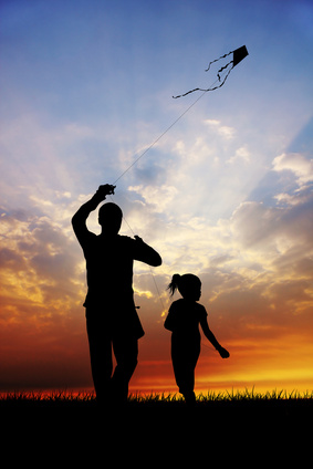 girl and father with kite at sunset
